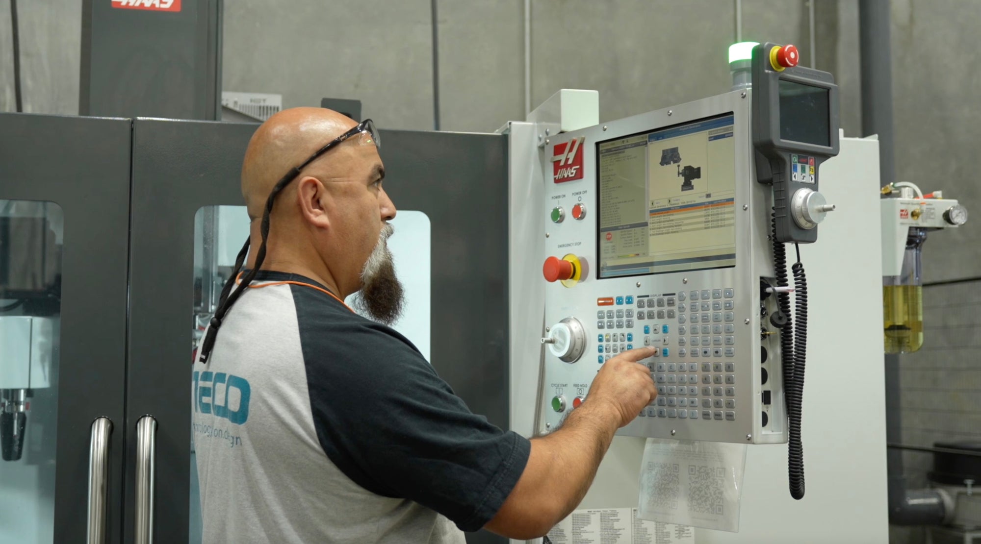 Employee entering data into CNC machine