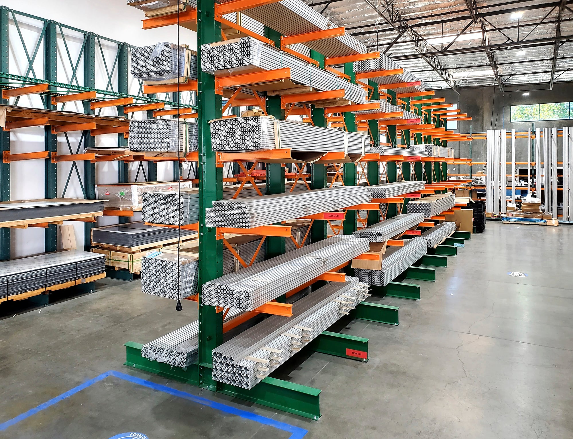 Green and orange shelving with metal organized on the shelves 