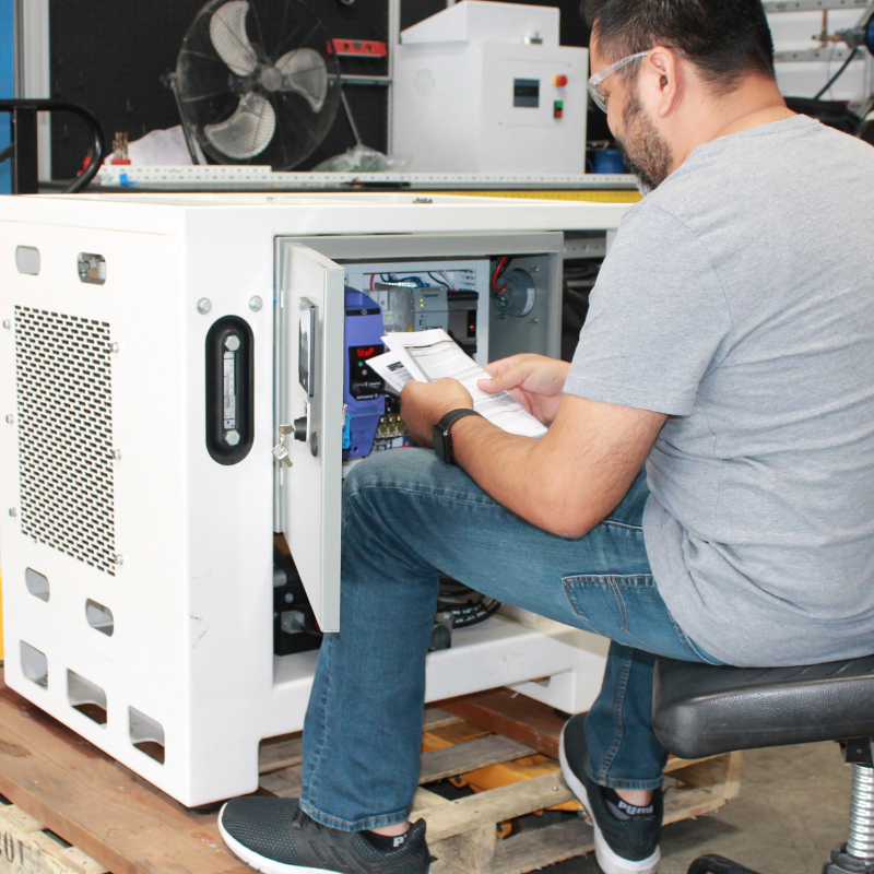Electrical Engineer holding a manual while programming 