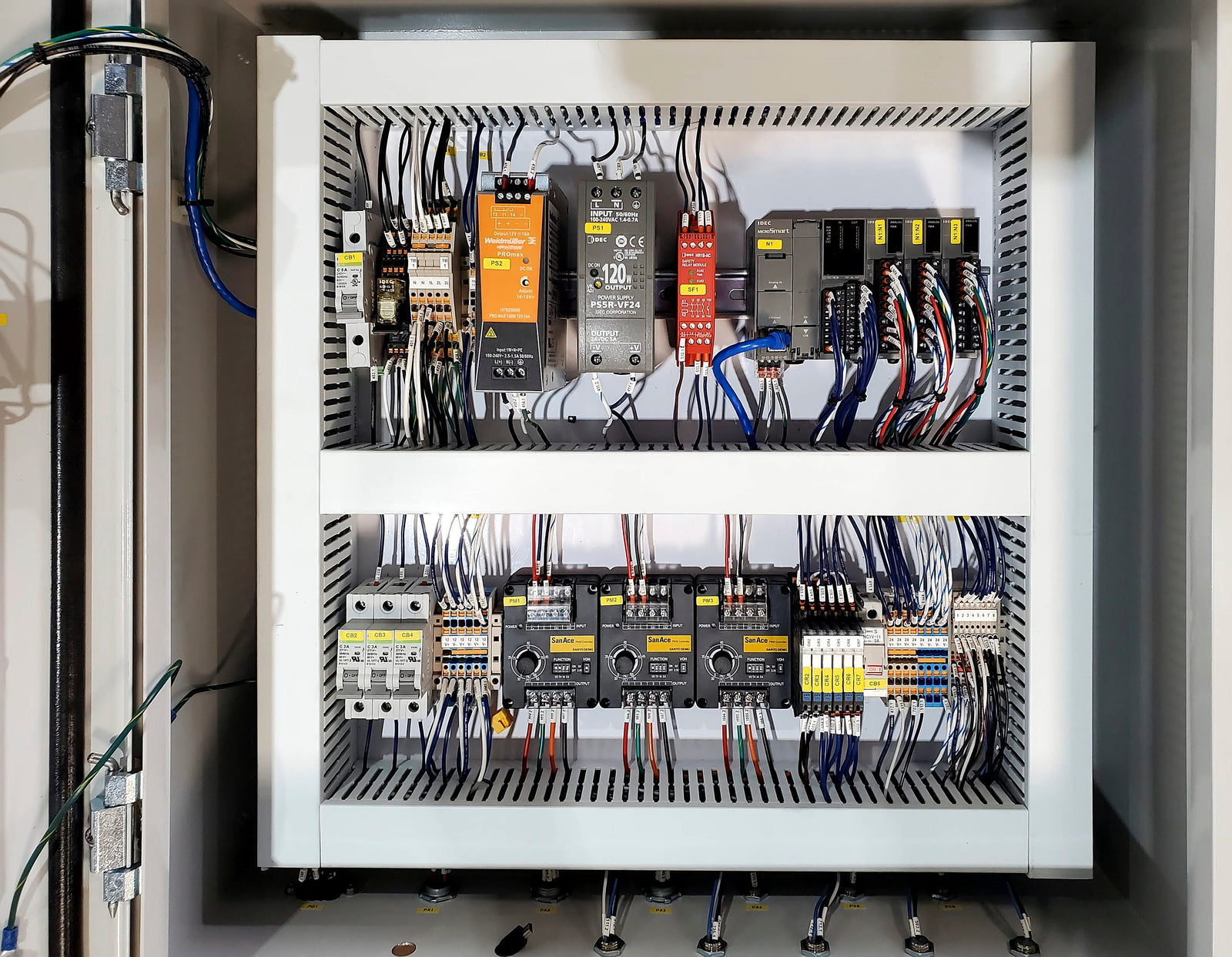 Electrical panel with various wires and components inside a cabinet